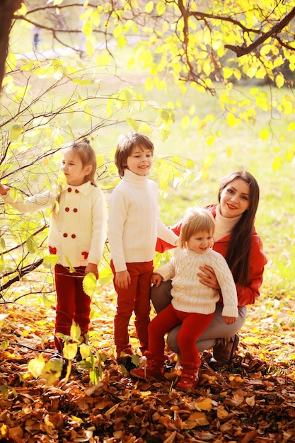 Young family on a walk in the autumn park on a sunny day Happiness to be together