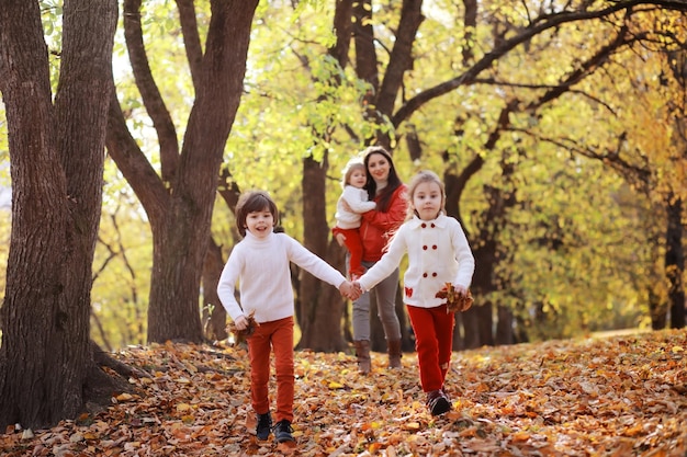 Young family on a walk in the autumn park on a sunny day Happiness to be together