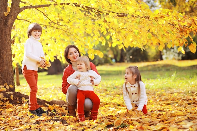 Young family on a walk in the autumn park on a sunny day Happiness to be together