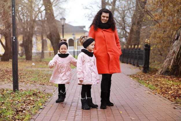 Young family on a walk in the autumn park on a sunny day Happiness to be together