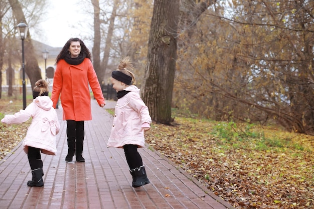 Young family on a walk in the autumn park on a sunny day Happiness to be together