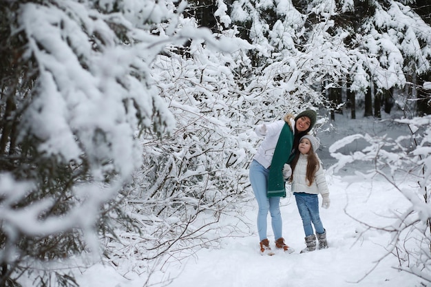 Young family for a walk. Mom and daughter are walking in a winter park.