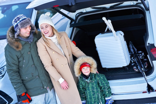 Young family during winter trip car trunk in bacground. High quality photo