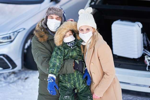 Young family during winter trip car trunk in bacground. High quality photo