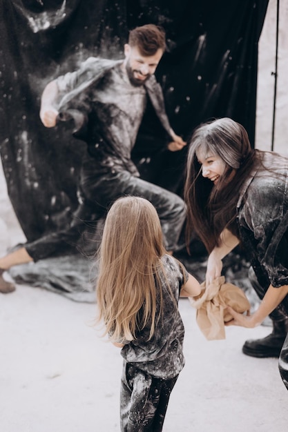 Young family with 2 kids dressed in black clothes posing for a photo, Family with two daughters