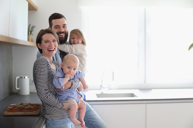 Young family with daughter and son in the kitchen