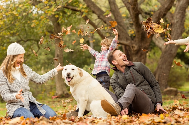 Young family with a dog in leaves