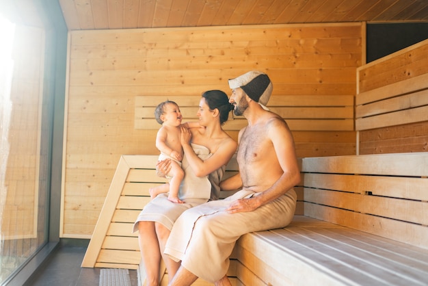 Young family with a little boy in sauna