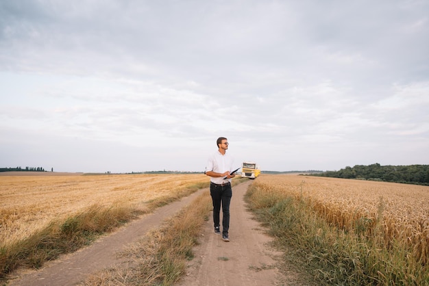 Young farmer engineer standing on wheat field