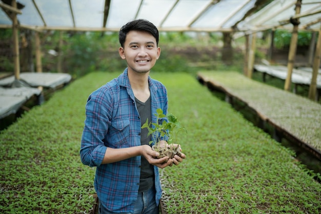 young farmer holding seed plant at the farm smart farming photo concept