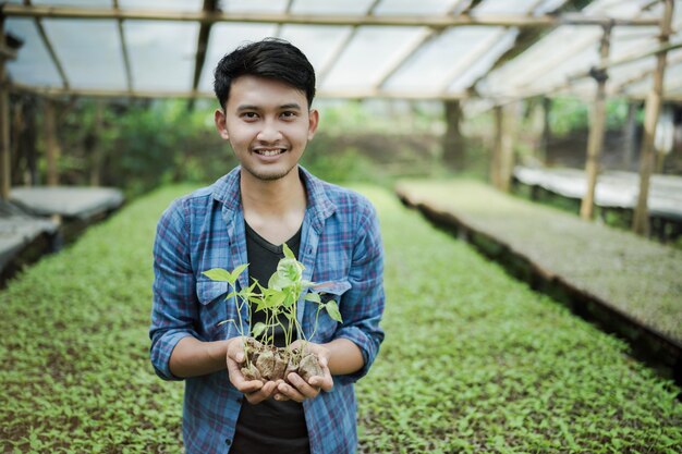 young farmer holding seed plant at the farm smart farming photo concept