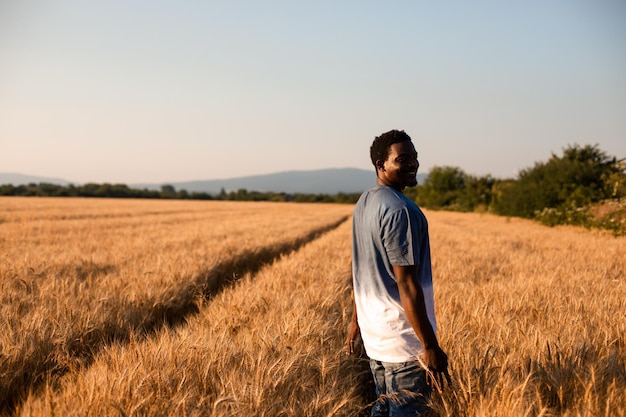 Young farmer standing in the middle of the field