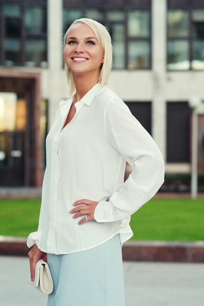 Young fashion blond woman walking on the street