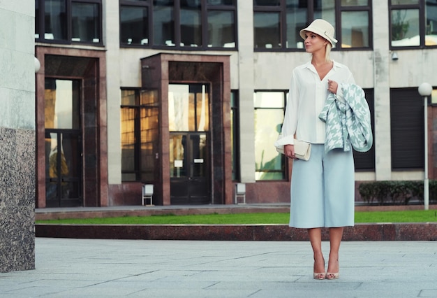 young fashion blond woman walking on the street