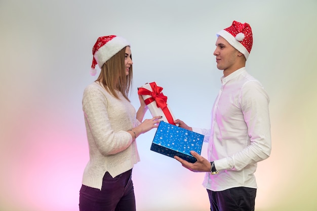 Young, fashion couple celebrating St. Valentine's Day giving presents to each other