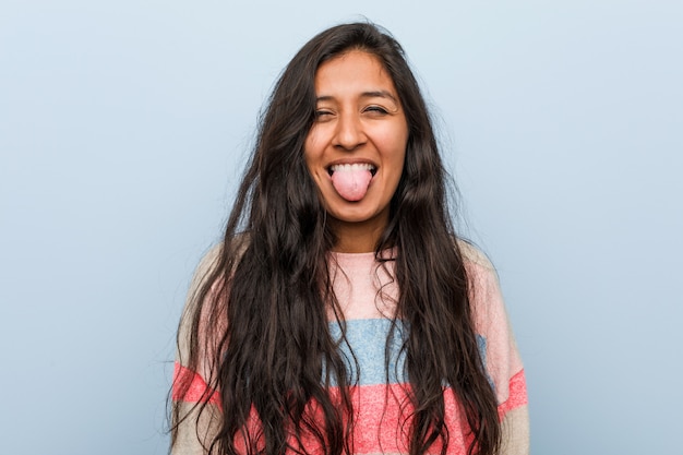 Young fashion indian woman funny and friendly sticking out him tongue