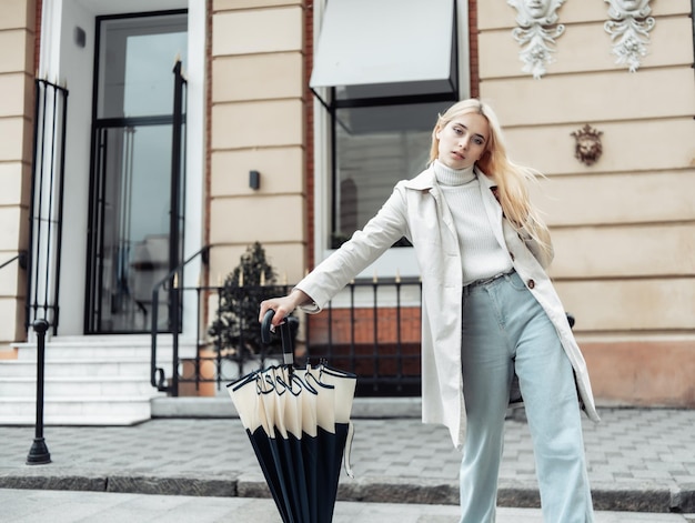 Young fashion woman with umbrella walking stick in the city