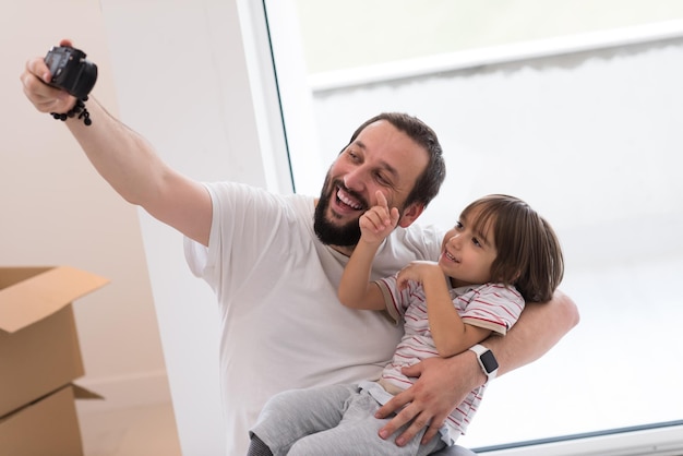 young father and his son photographed themselves with cardboard boxes around them while moving into their new home