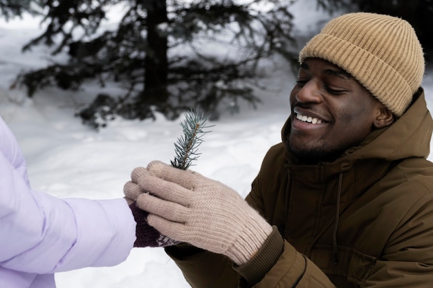 Young father receiving gift from daughter on a snowy winter day