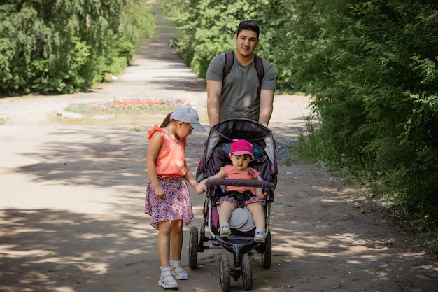 young father with his daughters walking in a park