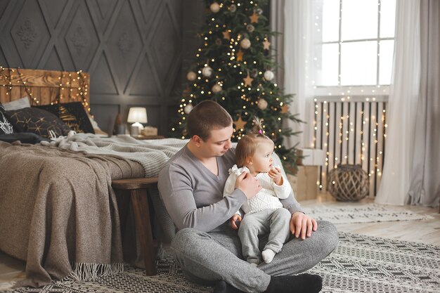 Young father with his little baby girl on christmas background