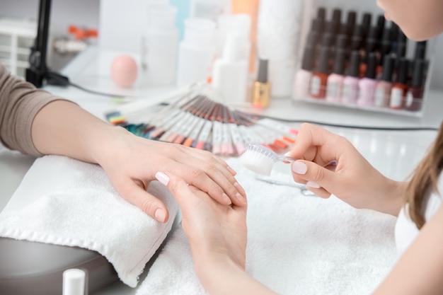 Young female in beauty salon nail care clean