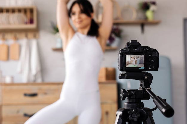 Young female blogger recording sports video at home