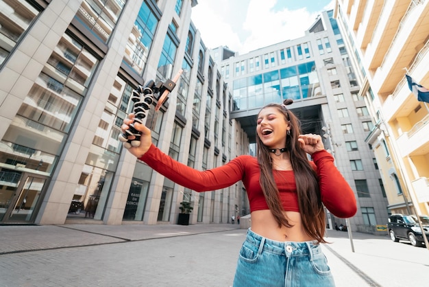 Young female blogger with smartphone streaming on the street