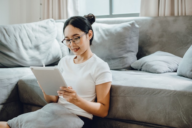 Young female business woman work at home with tablet or laptop computer, using online communication technology, asian people in happy lifestyle, beautiful girl person stay at home