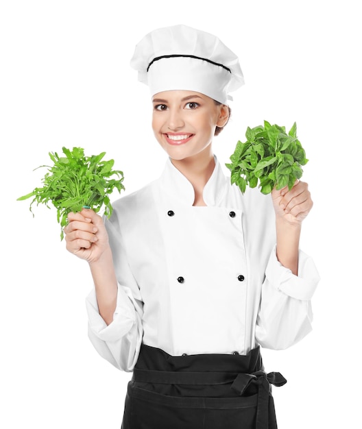 Young female chef with herbs on white background