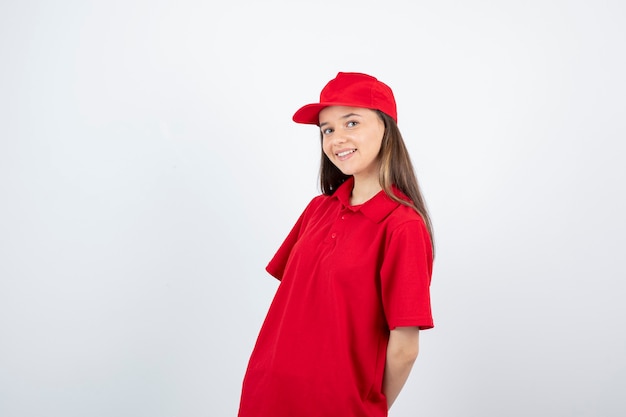 young female courier in red uniform feeling happy. 