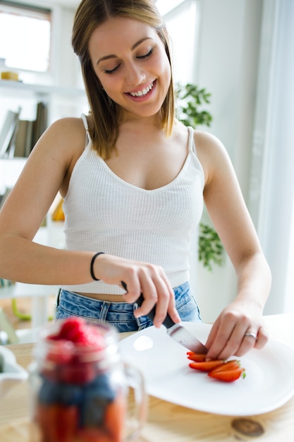 "Young female cutting strawberry. "