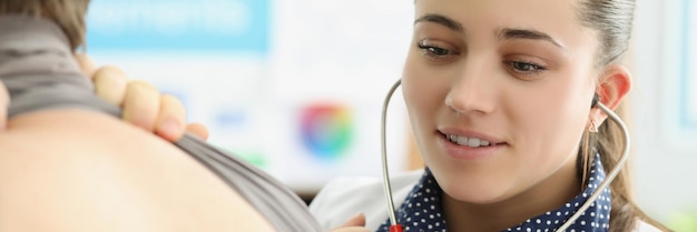 Young female doctor listen to patients back with stethoscope equipment