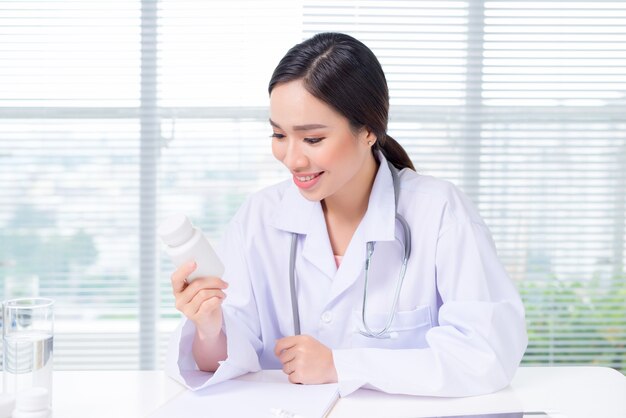 Young female doctor looking concentrated while sitting at the table