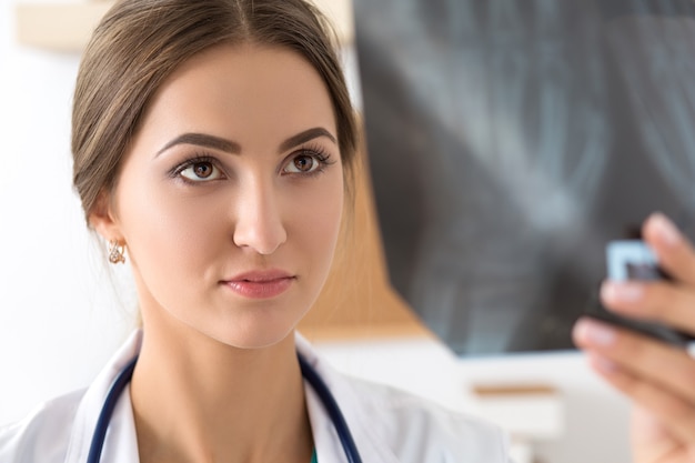 Young female doctor looking at lungs x ray image