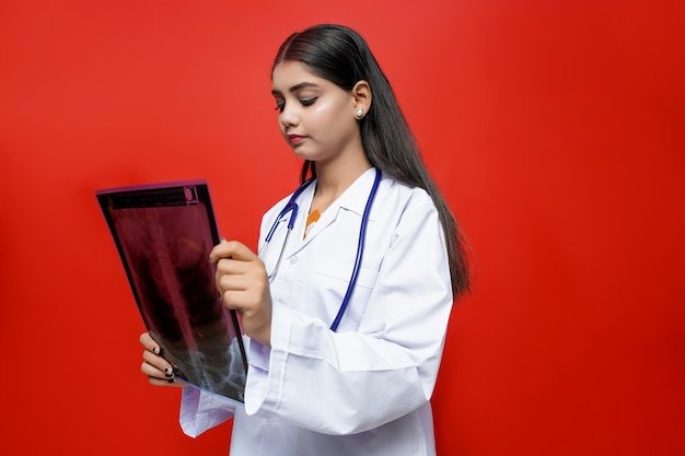 young female doctor looking on x-ray wearing coat and stethoscope indian pakistani model