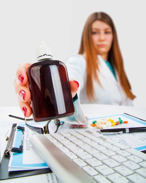 Young female doctor with bottle of pills in her hand