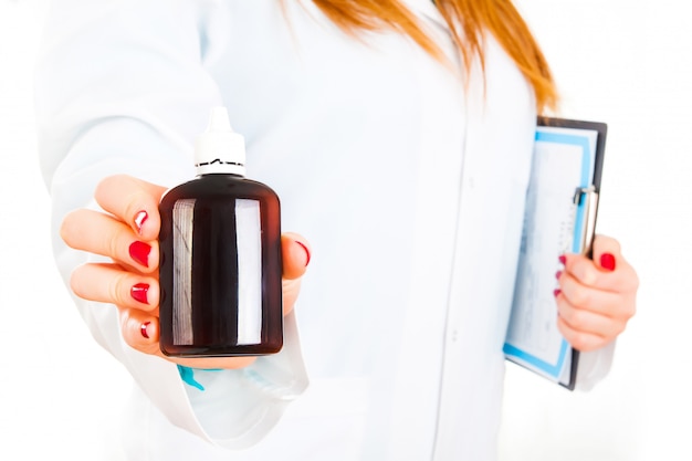 Young female doctor with bottle of pills in her hand