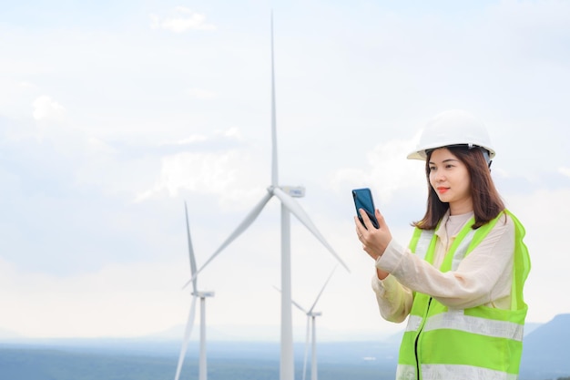 Young female engineer working at a wind farm Renewable power generation station in wind turbine field Young female engineer discussing work on the phone