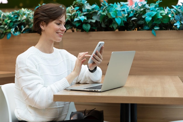 Young female freelancer working on a laptop in a trendy cafe