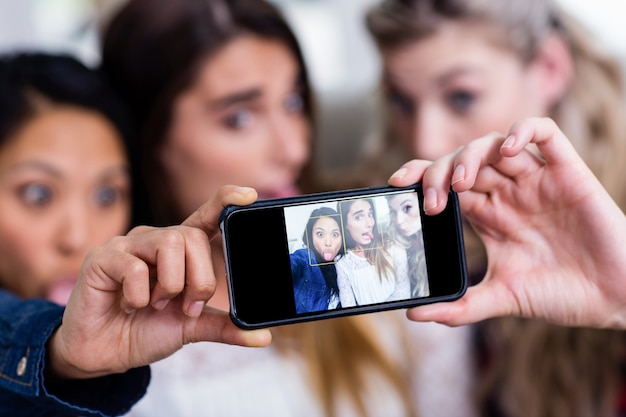 Young female friends taking selfie