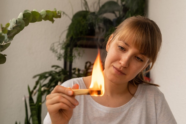 Young female looking how aroma wooden stick burning aromatherapy incense practice