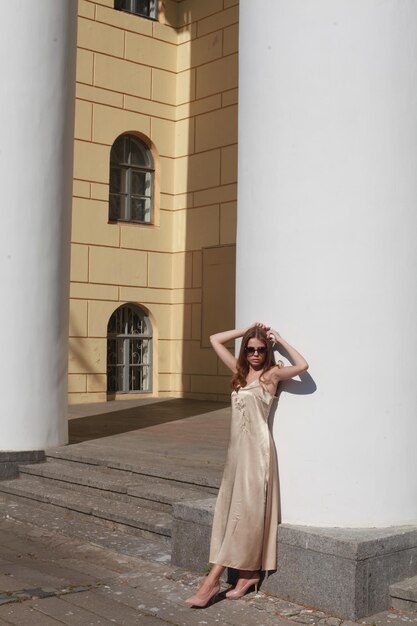 Young female model posing against column