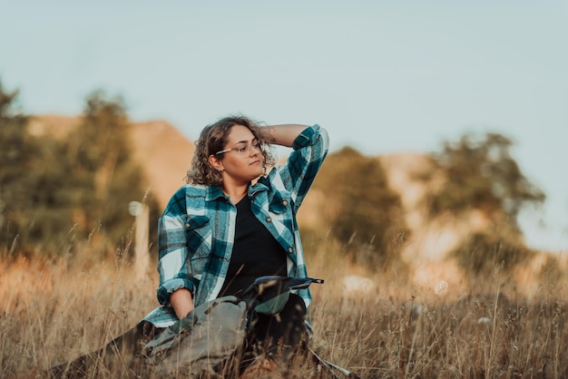 A young female mountaineer sits and rests on a rock after climbing a mountain