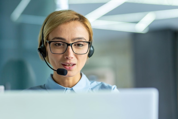 Young female office worker close up businesswoman with headset phone for video call talking to