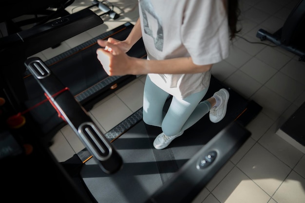 Young female person doing jogging on a treadmill in a fitness center