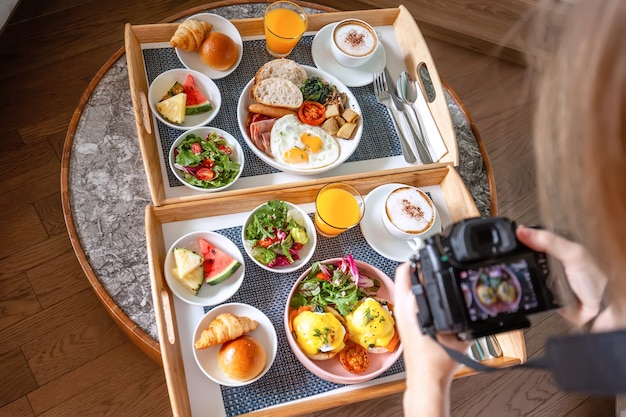 Young female photographer make photoshoot of fresh breakfast in hotel