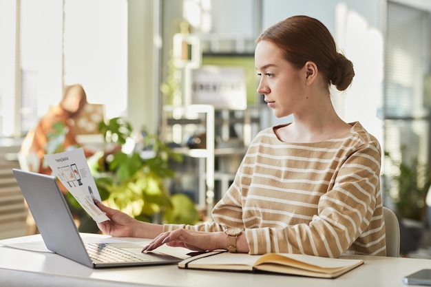 Young Female Professional At Workplace Side View