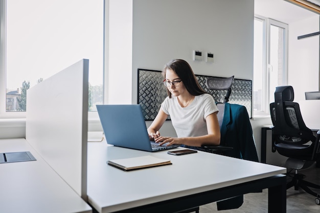 Young female programmer web developer working on computer software in modern office web designer