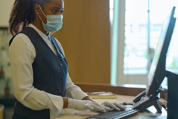 Young female receptionist entering personal data of hotel guests into database